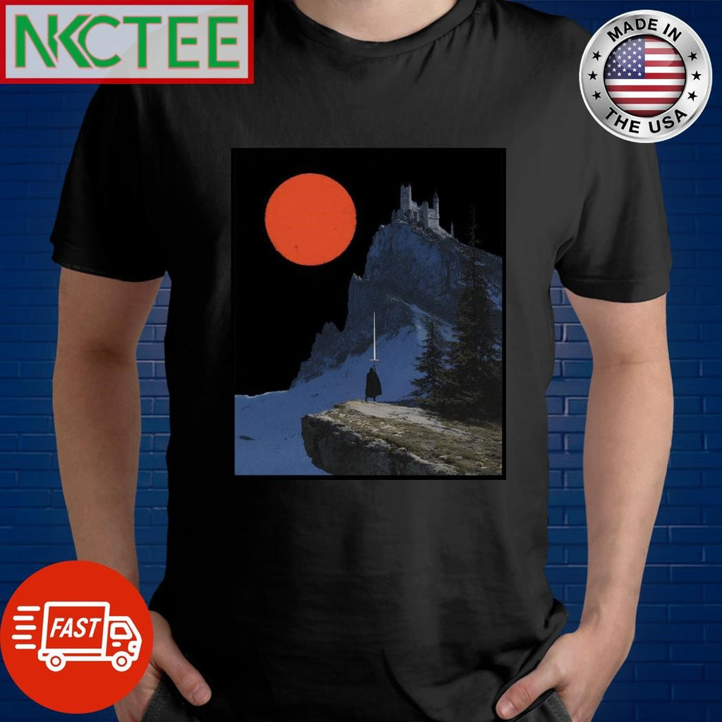 Robed figure wielding a glowing sword, overlooking a snow-dusted mountain with a castle perched atop, under a large, red celestial body shirt